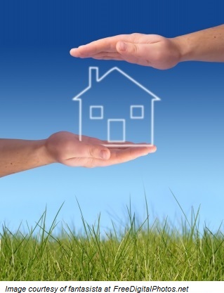 Two hands holding an image of a house