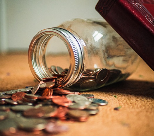 A fallen over jar of coins